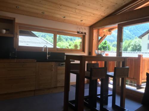 - une cuisine avec une table, des chaises et des fenêtres dans l'établissement La Para, à Chamonix-Mont-Blanc