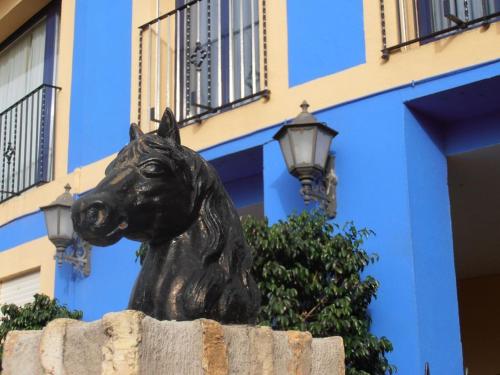 a statue of a black bear sitting on the side of a building at Hotel Caballo Negro in Puerto Real