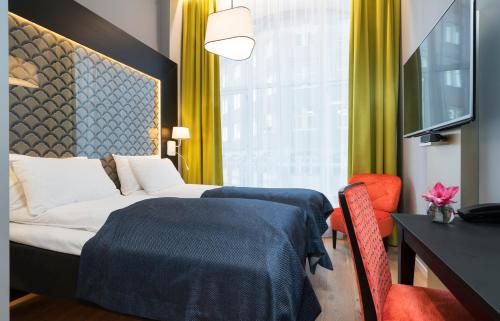 a hotel room with a bed and a table and chairs at Thon Hotel Spectrum in Oslo