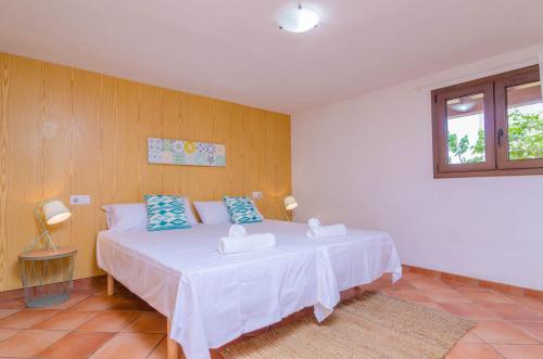 a bedroom with a white bed with blue pillows at Sa Caseta De Ses Vaques. Son Covas (Sa Vaqueria 2) in Campos
