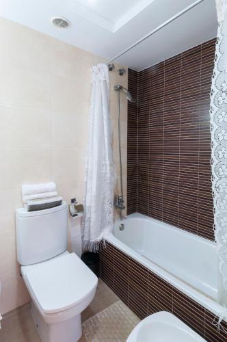 a bathroom with a toilet and a bath tub at Poema in Oliva