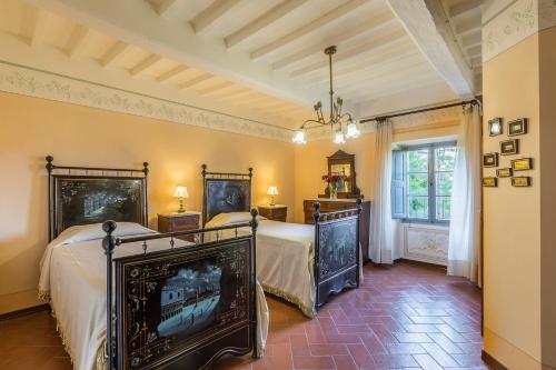 a bedroom with two beds and a fireplace at Palazzo Rosadi by PosarelliVillas in Monterchi