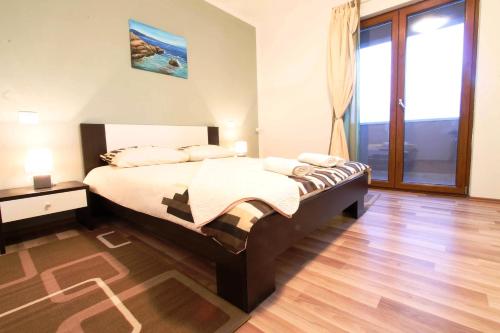 a bedroom with a bed and a large window at Danica in Smoljanci