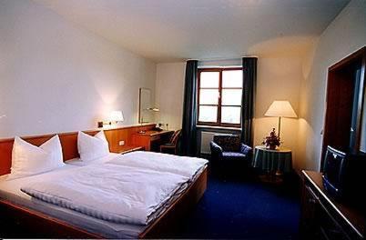 Schlafzimmer mit einem Bett, einem Schreibtisch und einem Fenster in der Unterkunft Gasthof Hotel Rückerl in Walderbach