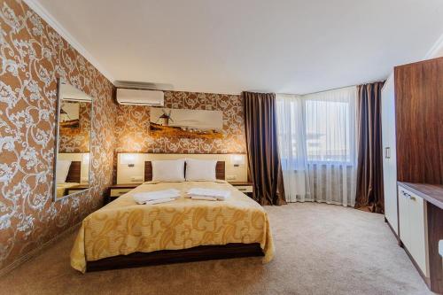 Un dormitorio con una cama grande y un espejo grande. en Hotel Alisa, en Pavel Banya