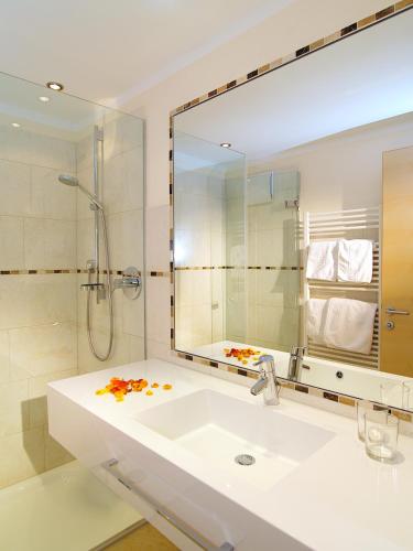 a bathroom with a sink and a shower and a mirror at Romantica Schlössl in Fiss