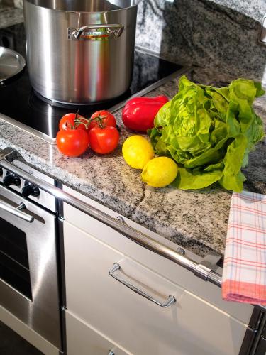a kitchen counter with tomatoes and lettuce and a pot at Romantica Schlössl in Fiss