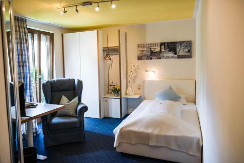 a hotel room with a bed and a desk and a chair at Hotel Domizil in Ingolstadt