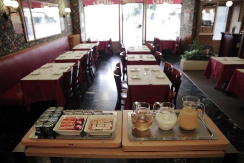 Un comedor con mesas con platos de comida y bebidas. en Hôtel du Cheval Rouge, en Versalles