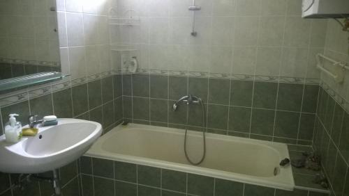 La salle de bains est pourvue d'une baignoire et d'un lavabo. dans l'établissement Eva vendégház, à Balatonlelle