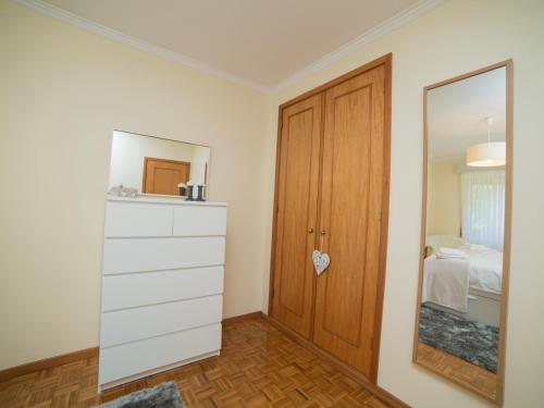 um quarto com uma cómoda e um armário com um espelho em OPORTO GUEST Vila do Conde River & Sea em Vila do Conde