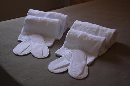 a pair of towels and slippers on a bed at Aparthotel Marsol in Castelldefels