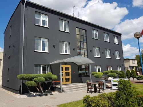 a black building with a yellow door at Hemma rooms by IKEA in Zbąszyń