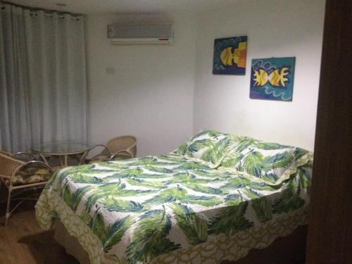 a bedroom with a bed with a comforter on it at Victory Business Flat in João Pessoa