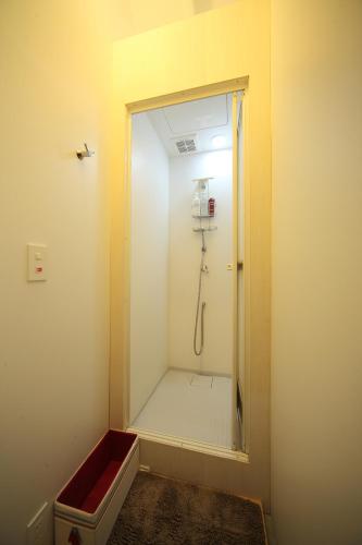 a bathroom with a shower with a red tub at Koyasan Guesthouse Kokuu in Koyasan