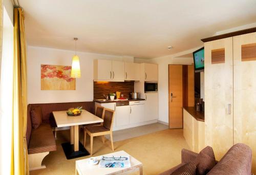 a living room with a table and a kitchen at Romantica Schlössl in Fiss