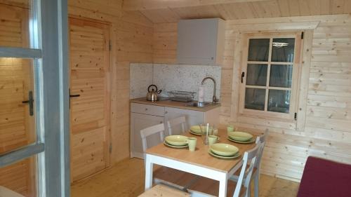 a kitchen with a table and chairs in a room at Domki Przy Orzechu in Lubin