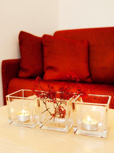 a table with three glass vases and candles on it at Romantica Schlössl in Fiss