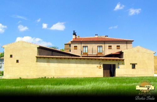 a large brick building in a field of green grass at Hotel Rural Rincón de Doña Inés in Villanueva de la Condesa