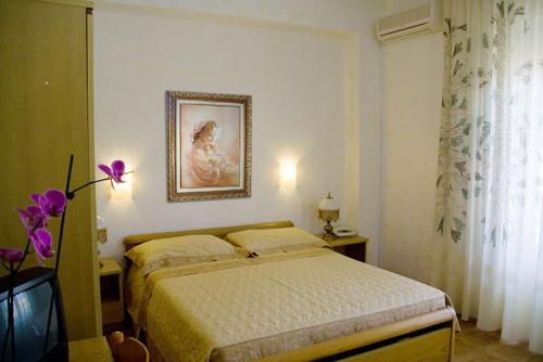 ブリアーティコにあるHotel Ristorante Solariのベッドルーム1室(ベッド1台付)が備わります。壁に絵が飾られています。