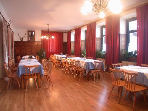 ゴーザウにあるJugendgästehaus Gosauschmiedのダイニングルーム(テーブル、椅子、赤いカーテン付)