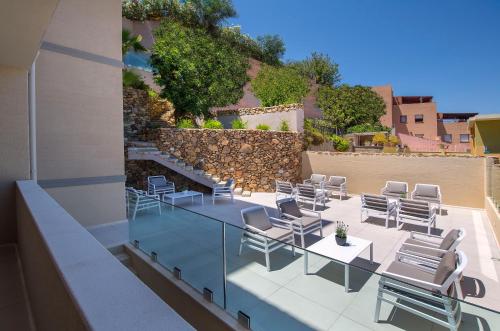 a patio with chairs and tables on a building at Domu Simius Life Style Hotel in Villasimius