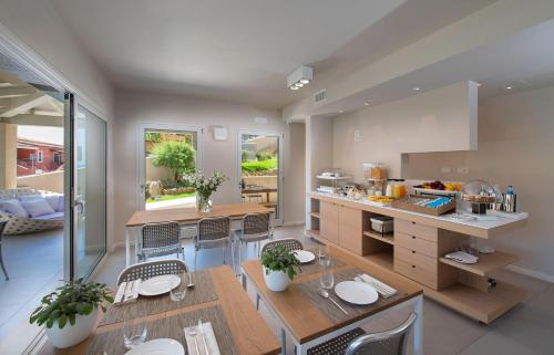 a kitchen with a table and chairs and a counter at Domu Simius Life Style Hotel in Villasimius