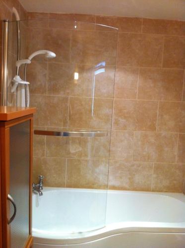 a shower with a glass door in a bathroom at Bankfoot Inn in Bankfoot