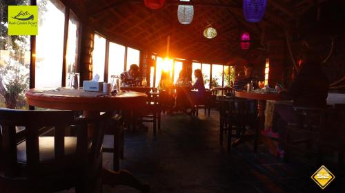 a group of people sitting at tables in a restaurant at Rock Garden Resort in Pokhara
