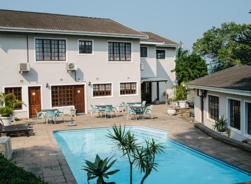 a swimming pool in front of a house at African Sands B&B in Amanzimtoti
