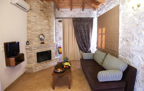 a living room with a couch and a fireplace at Anigraia in Paralion astros