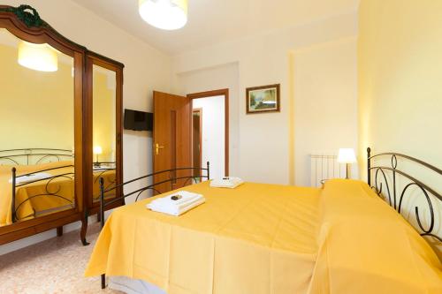 a bedroom with a yellow bed and a mirror at B&B La Primula in Pompei