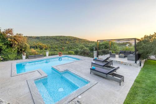 een zwembad met ligstoelen bij Villa Boulder in Okrug Donji