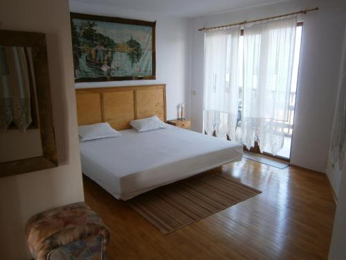 een slaapkamer met een wit bed en een groot raam bij Apartment Apolonia 14 in Sozopol