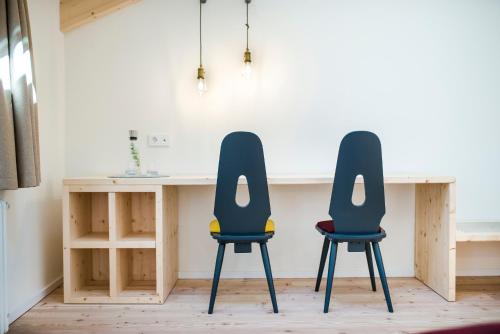 two chairs sitting next to a desk in a room at Zum Hirschen Boutique Hotel Val di Non in Unsere Liebe Frau im Walde