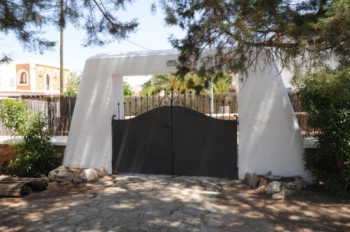 a large black gate in a white fence at Chalet Torralba - Villa at Hotel Osiris in San Antonio