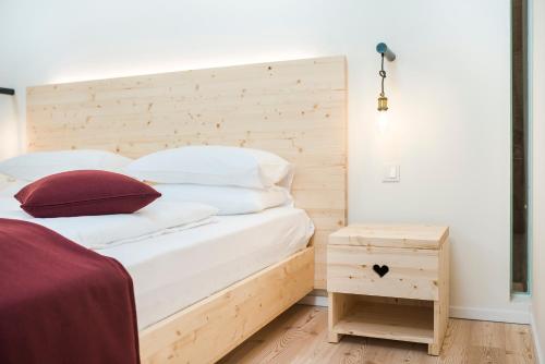 a bedroom with a bed with a wooden headboard at Zum Hirschen Boutique Hotel Val di Non in Unsere Liebe Frau im Walde
