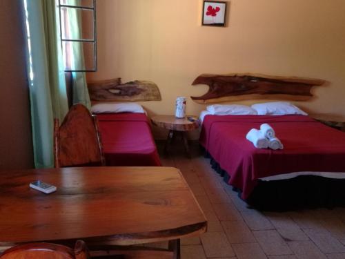 a hotel room with two beds and a table and a table at Posada Iguazu Royal in Puerto Iguazú