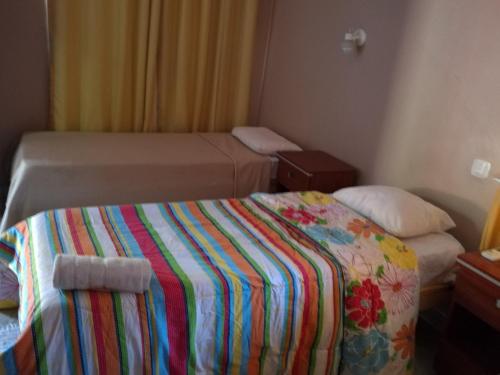 1 dormitorio pequeño con 1 cama con una manta colorida en Posada Iguazu Royal en Puerto Iguazú