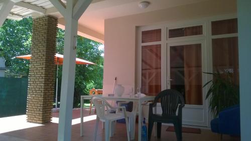 une salle à manger avec une table et des chaises sur une terrasse dans l'établissement Eva vendégház, à Balatonlelle