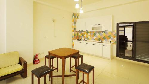 a kitchen with a table and stools in a room at Warm Breeze Stay in Hualien City