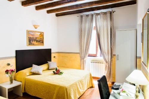 um quarto com uma cama amarela e uma janela em Domus Popolo em Roma