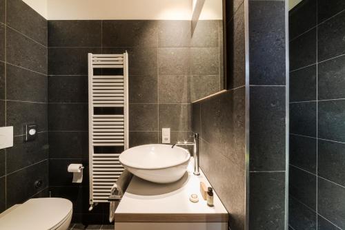 a bathroom with a white sink and a toilet at Zum Hirschen Boutique Hotel Val di Non in Unsere Liebe Frau im Walde