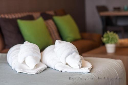 a pile of towels on top of a bed at Baan Peang Ploen Huahin by Alice in Hua Hin