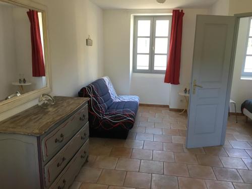 een kamer met een stoel, een dressoir en een spiegel bij Appartement Paisible in Fontaine-de-Vaucluse