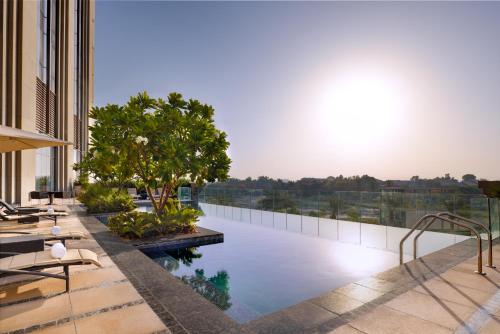 an outdoor patio with a pool and trees at Hyatt Regency Creek Heights Residences in Dubai