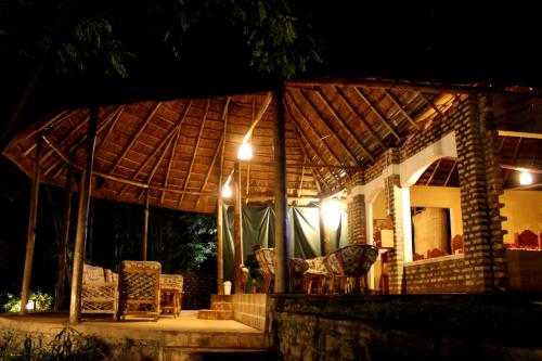 a house with a thatched roof at night at Irungu Forest Safari Lodge in Katunguru