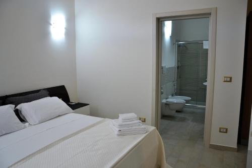 ポルト・チェザーレオにあるPalazzo Greco Case Vacanzeのベッドルーム1室(ベッド1台付)、バスルーム(トイレ付)