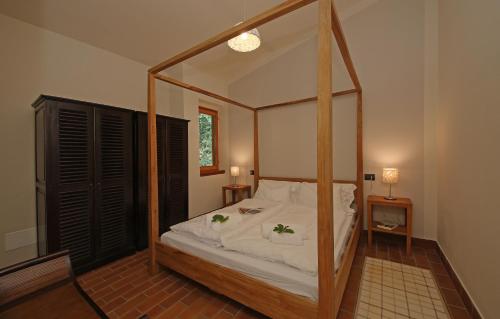 ein Schlafzimmer mit einem Himmelbett und einem Spiegel in der Unterkunft La Fontanina in Vobarno