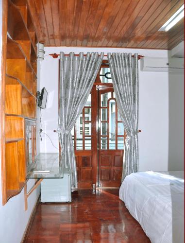 a bedroom with a bed and a desk and a window at Ngoc Tung Mini Hotel in Hue